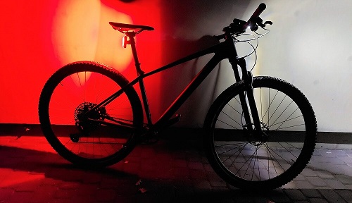 Rower w ciemności z czerwonym światłem w tyle